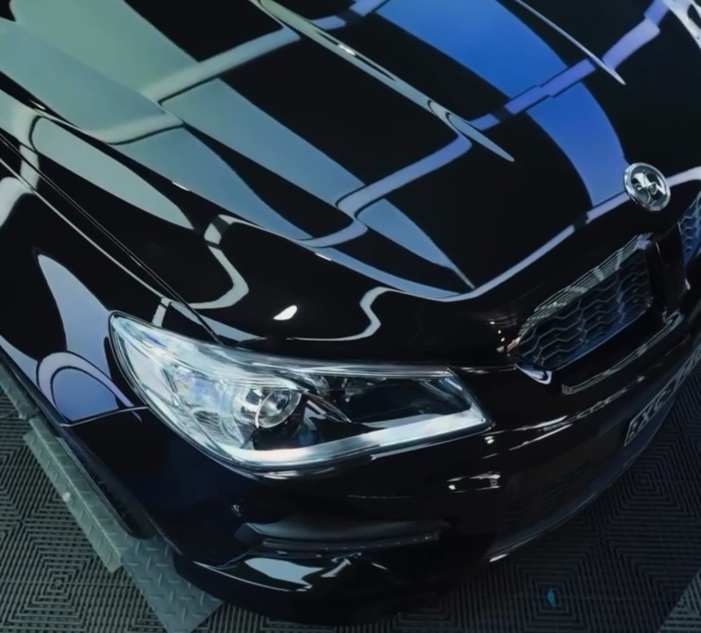 Clear headlight lens and glossy black bodywork after detailing