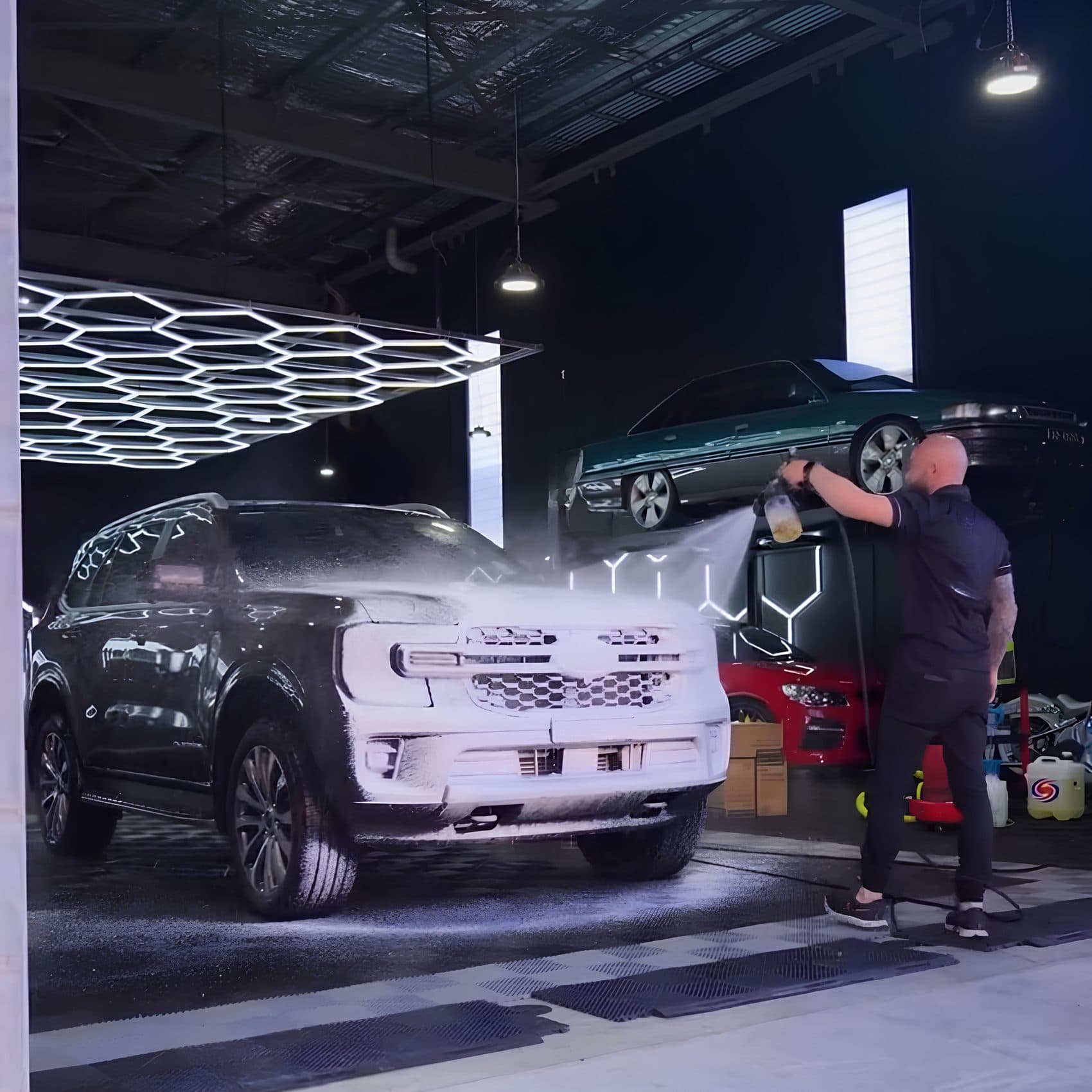 SUV covered in snow foam during the wash stage of a full detail